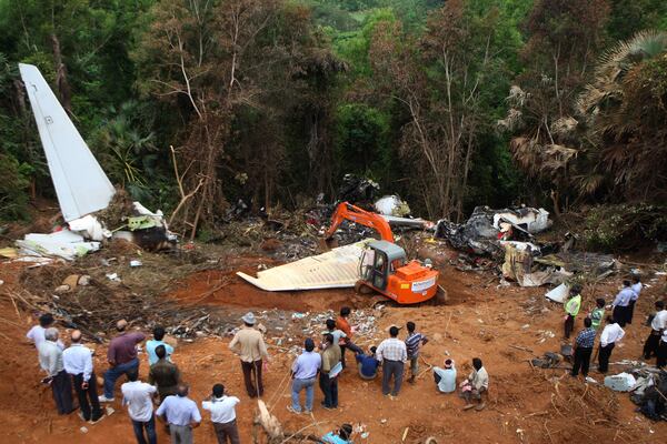 FILE - An earth remover cleans the site of the crash of an Air India Boeing 737-800 plane in Mangalore, in the southern Indian state of Karnataka, Monday, May 24, 2010. (AP Photo/Rafiq Maqbool, File)