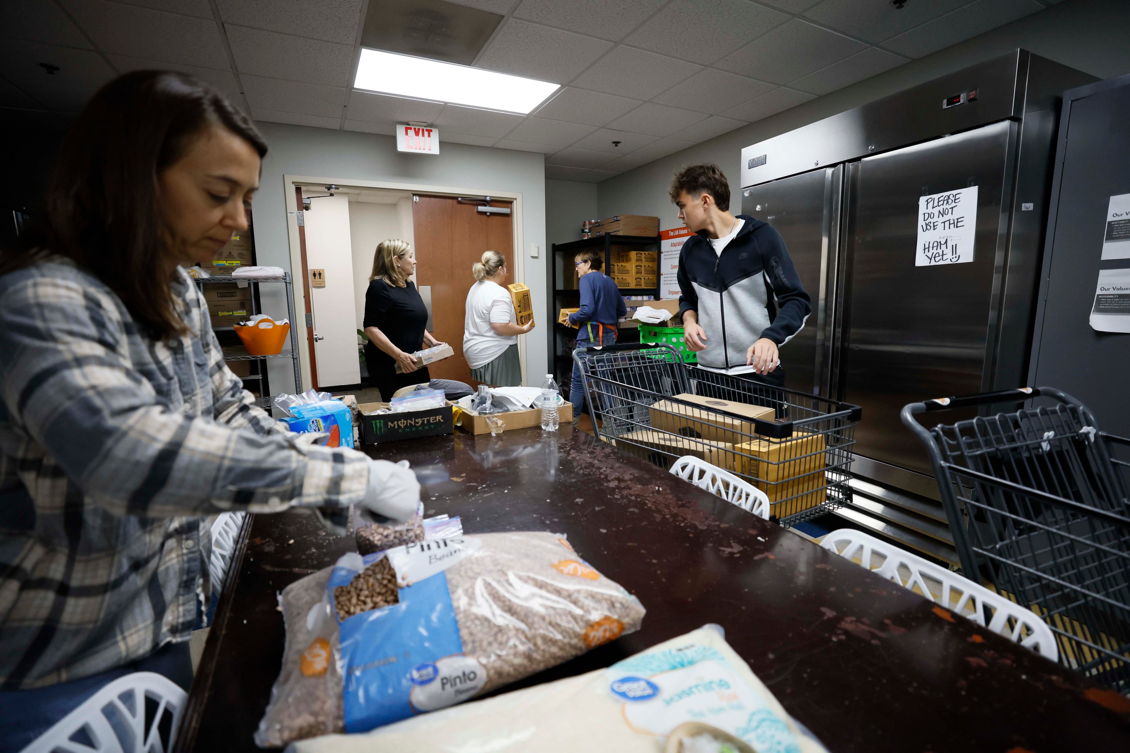 Volunteers from the Latin American Association, including (from left) Ellen Goldwasser, Ellen Levitt, Jacky Uruzmendi and Nick Nele, are seen organizing boxes and bags of food on Monday, Nov 24, 2025. (Miguel Martinez/ AJC)