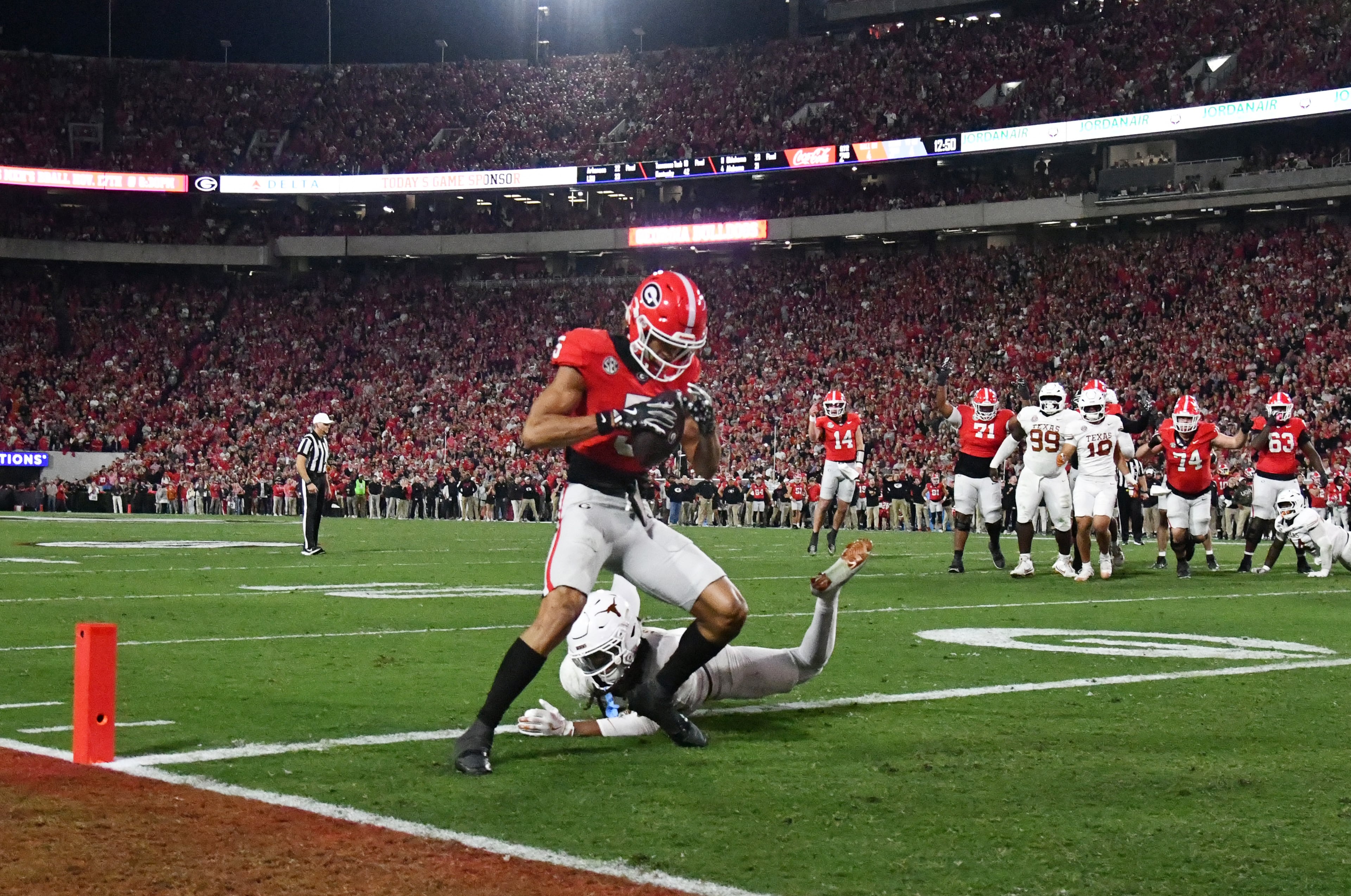Georgia wide receiver Noah Thomas (5) scores a touchdown past Texas defensive back Kade Phillips (11) during the first half in an NCAA football game at Sanford Stadium, Saturday, November 15, 2025, in Athens. (Hyosub Shin / AJC)