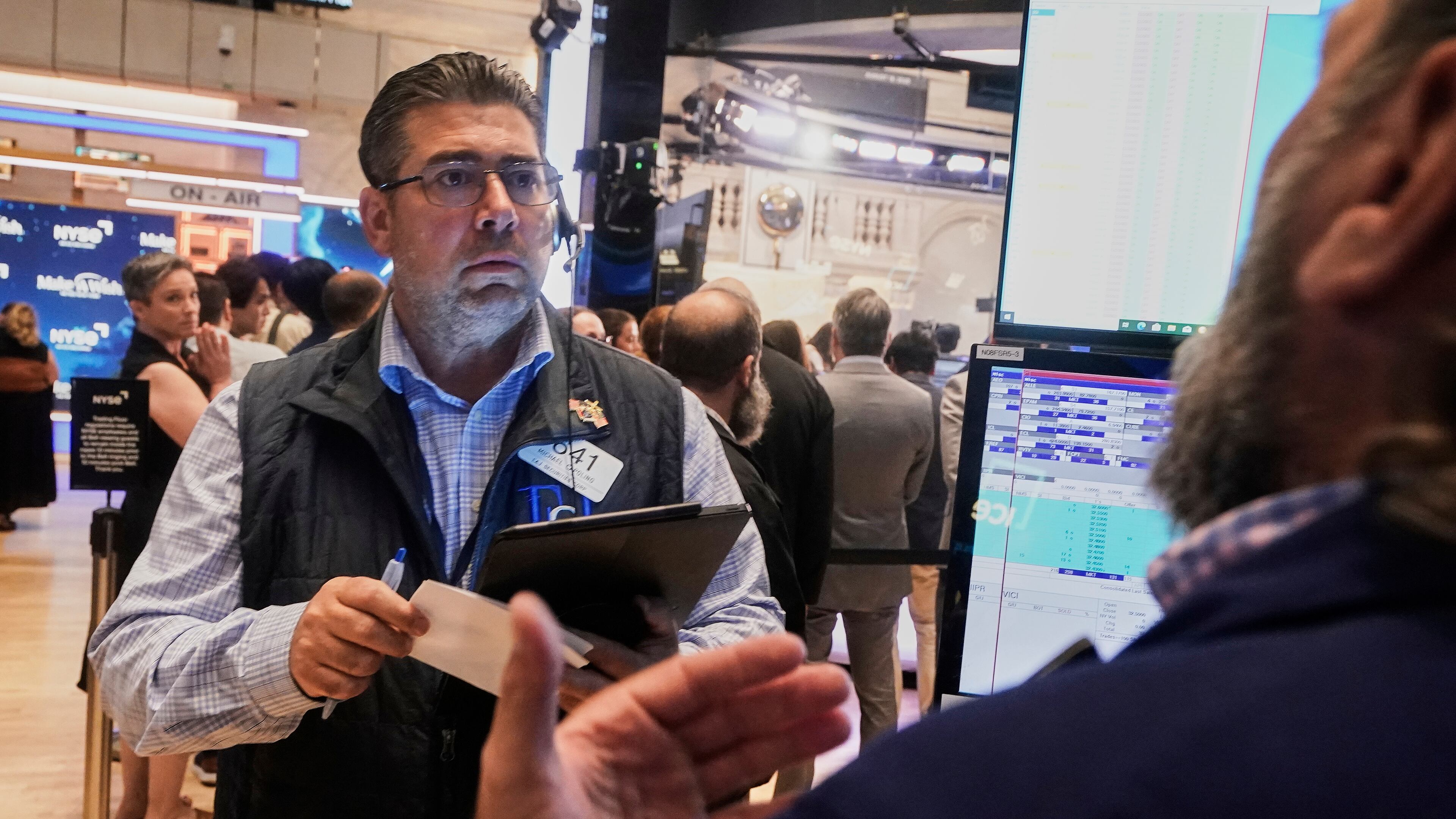 Trader Michael Capolino left, works on the floor of the New York Stock Exchange, Monday, Aug. 18, 2025. (AP Photo/Richard Drew)
