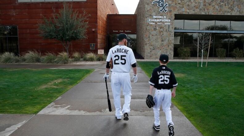 FILE - In this Feb. 28, 2015, file photo, Chicago White Sox's Adam LaRoche, left, and his son Drake walk to the White Sox's clubhouse during a photo day before a baseball spring training workout in Phoenix. Kudos to Adam LaRoche for wanting to spend time with his son, and walking away from a $13 million salary to make sure that happened. But there's nothing wrong with the White Sox telling the now-retired first baseman that "Bring Your Child To Work Day" couldn't be every day. (AP Photo/John Locher, File)