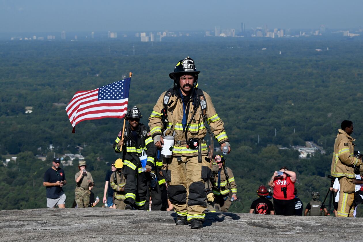 Firefighters reach the top of the mountain during the annual 9/11 Stone Mountain Memorial Climb at Stone Mountain Park on Friday, Sept. 11, 2026, in Stone Mountain. Hundreds of firefighters and other first responders hiked one mile up Stone Mountain, equivalent to climbing 160 flights of stairs, in memory of those killed in the Sept. 11, 2001, terrorist attacks. (Hyosub Shin/AJC)