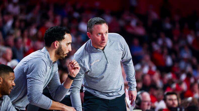 Georgia head coach Mike White (right) confers with assistants Akeem Miskdeen (left) and  Erik Pastrana. (Tony Walsh/UGA Athletics)