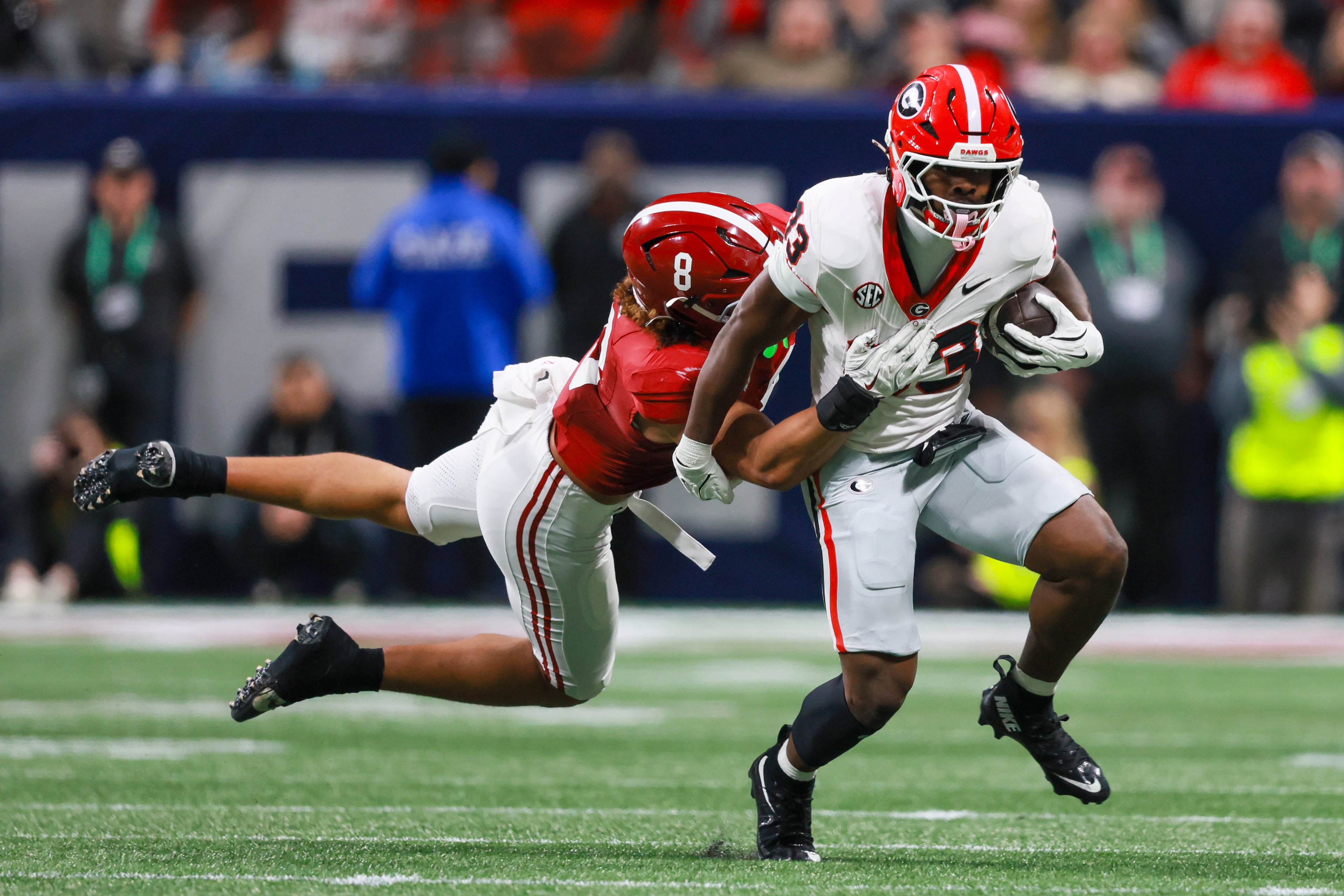 Georgia running back Chauncey Bowens (33) runs against Alabama linebacker Justin Hill (8) during the second quarter of the SEC Championship game at Mercedes-Benz Stadium, Saturday, Dec. 6, 2025, in Atlanta. (Jason Getz / AJC)