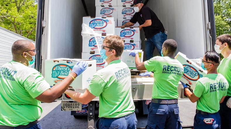 DeKalb County Fire Rescue recruits help distribute food at the giveaway. (Jenni Girtman for Atlanta Journal Constitution)