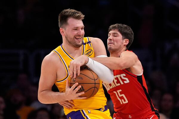 Houston Rockets guard Reed Sheppard, right, reaches in on Los Angeles Lakers guard Luka Doncic during the first half of an NBA basketball game Friday, April 11, 2025, in Los Angeles. (AP Photo/Mark J. Terrill)