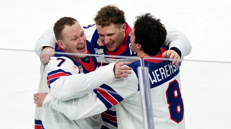 FILE - United States' Brady Tkachuk (7), Matthew Tkachuk, center, and Zach Werenski (8) celebrate after their overtime win against Canada in the men's ice hockey gold medal game at the 2026 Winter Olympics in Milan on Feb. 22, 2026. (AP Photo/Carolyn Kaster, File)