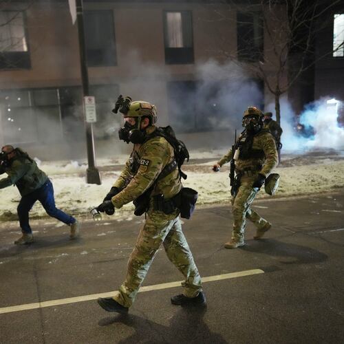 Federal agents try to clear demonstrators near a hotel, using tear gas during a noise demonstration protest in response to federal immigration enforcement operations in the city Sunday, Jan. 25, 2026, in Minneapolis. (AP Photo/Adam Gray)
