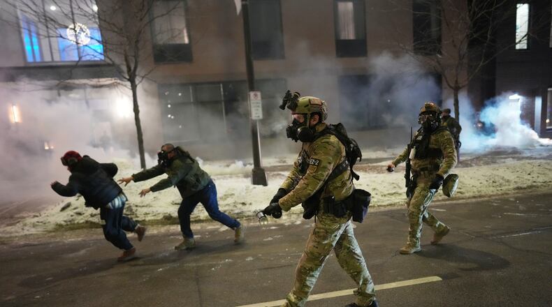 Federal agents try to clear demonstrators near a hotel, using tear gas during a noise demonstration protest in response to federal immigration enforcement operations in the city Sunday, Jan. 25, 2026, in Minneapolis. (AP Photo/Adam Gray)