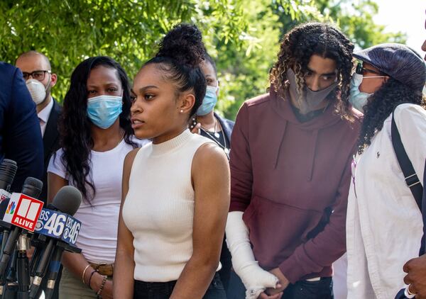 Spelman College student Taniyah Pilgrim speaks to the crowd while her boyfriend, Morehouse College student Messiah Young, right, listens to his mother, Genesis Young, at a press conference on the Morehouse campus Monday, June 1, 2020. The two were on their way to get dinner shortly after 9 p.m. on Saturday, May 30, when Atlanta police pulled them from their vehicle, tased them both and fractured Young’s arm. (Jenni Girtman for The Atlanta Journal-Constitution)