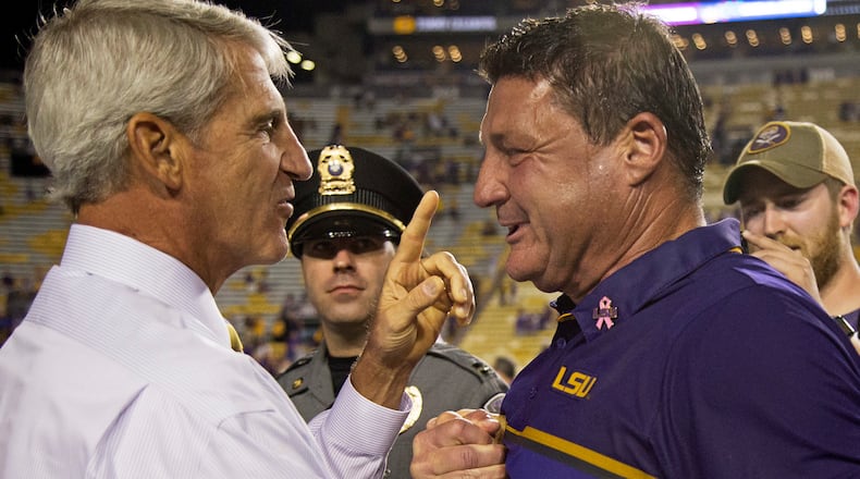 LSU AD Joe Alleva, here congratulating his interim football coach Ed Orgeron, is playing hardball on re-scheduling his game against Florida. (AP Photo/Max Becherer)