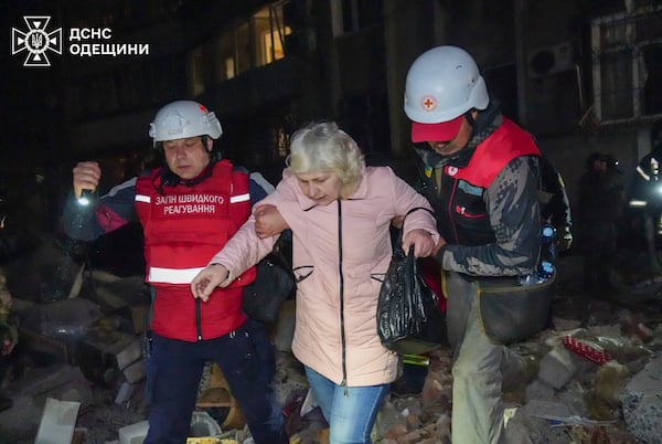 In this photo provided by the Ukrainian Emergency Service, rescuers help evacuate an elderly resident from her damaged house following Russia's air raid in Odesa, Ukraine, Thursday, May 1, 2025. (Ukrainian Emergency Service via AP)