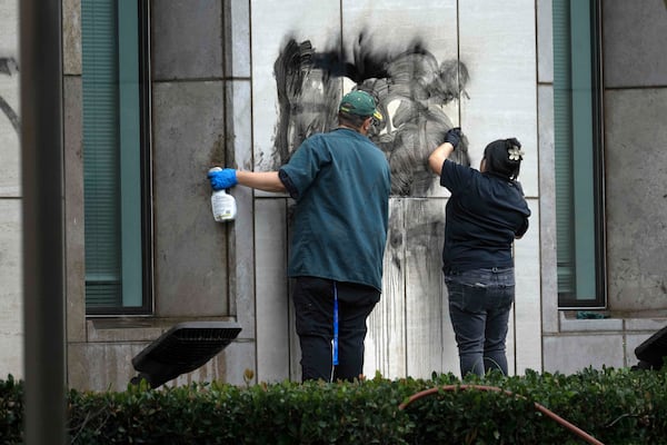 Workers remove graffiti from the Ronald Reagan Federal Building and Courthouse in Santa Ana, Calif., Tuesday, June 10, 2025, after Monday's protests against President Trump's ICE raids resulted in violence. (Mindy Schauer/The Orange County Register via AP)