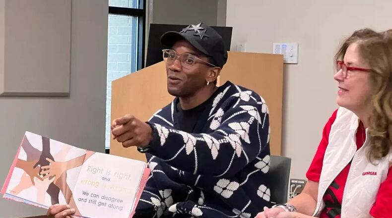 Malcolm Mitchell reads to children at the Sandy Springs library branch with Robin Perry, director of Coca-Cola Collaboration Centers. (Claudia Strange/Fulton County Library System)