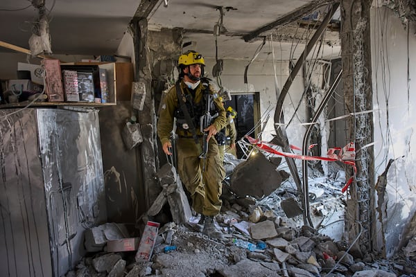 Israeli soldiers from the search and rescue unit work amid the rubble of residential buildings destroyed by an Iranian missile strike that killed several people, in Beersheba, Israel, on Tuesday, June 24, 2025. (AP Photo/Bernat Armangue)
