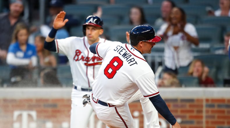 Atlanta Braves' Chris Stewart (8) slides into home for the second run scored off of Ender Inciarte's double in the second inning of a baseball game against the Philadelphia Phillies, Saturday, March 31, 2018, in Atlanta. (AP Photo/Todd Kirkland)