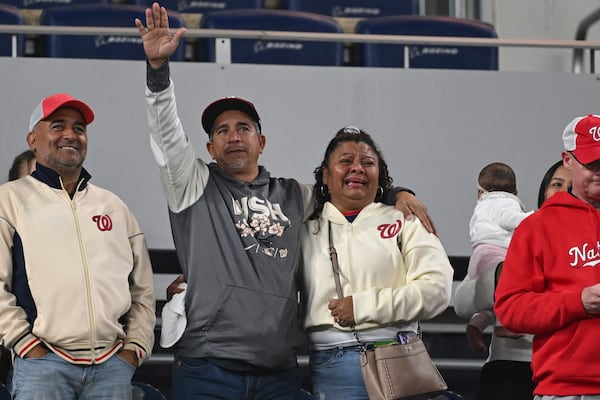 Washington Nationals' Keibert Ruiz parents acknowledge their son from the stands after a baseball game against the Atlanta Braves in Washington, Thursday, May 22, 2025. (AP Photo/Terrance Williams)