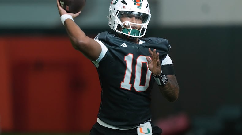 Miami quarterback Darian Mensah (10) throws a pass during a practice session at their training facility, Tuesday, Aug. 4, 2026, in Coral Gables, Fla. (AP Photo/Marta Lavandier)
