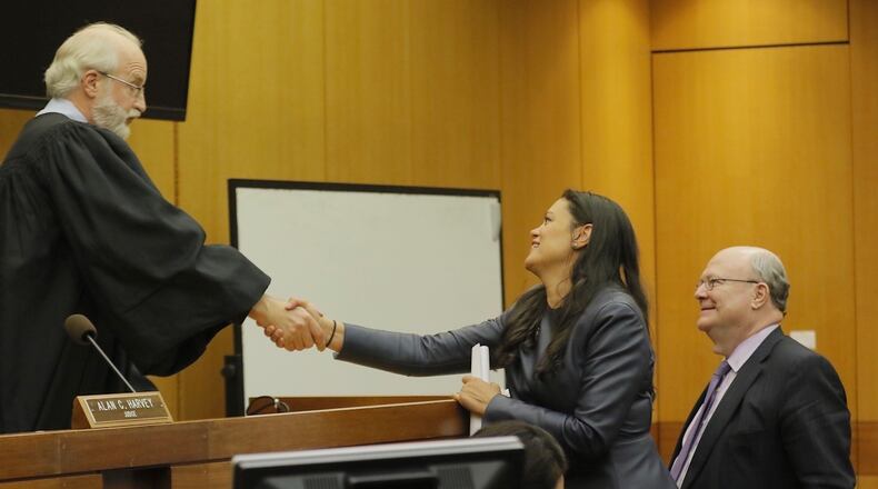 APS superintendent Meria Carstarphen shakes the hand of DeKalb County Judge Alan C. Harvey on Friday after he gave Fulton County permission to send tax bills.