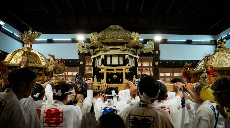 Festival participants carry Yasaka Shrine's Eastern Mikoshi back into the shrine's main hall following the "Mikoshi Arai" purification ritual ahead of the Gion Matsuri festival in Kyoto, western Japan, Friday, July 10, 2026. (AP Photo/Fred Mery)