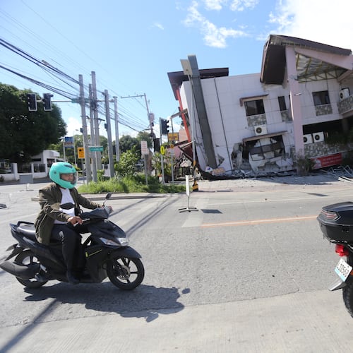 People on motorcycles pass by a collapsed structure after an earthquake in General Santos, Philippines on Monday, June 8, 2026. (AP Photo)