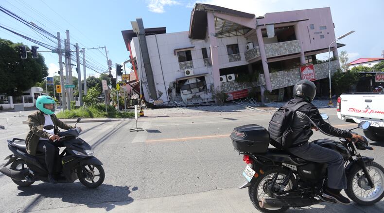 People on motorcycles pass by a collapsed structure after an earthquake in General Santos, Philippines on Monday, June 8, 2026. (AP Photo)