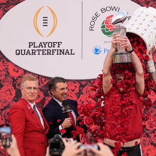 Indiana head coach Curt Cignetti holds the winner's trophy as he is doused with rose pedals by linebacker Aiden Fisher (4) after a win over Alabama in the Rose Bowl College Football Playoff quarterfinal game Thursday, Jan. 1, 2026, in Pasadena, Calif. (AP Photo/Mark J. Terrill)