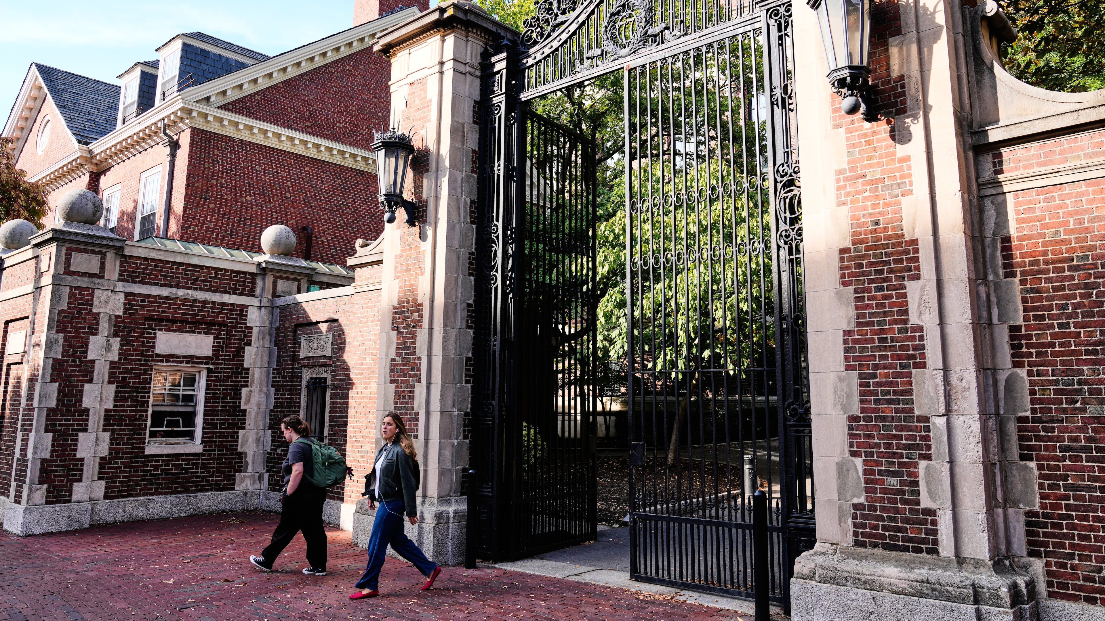 Two women walk through a gate from Harvard Yard at Harvard University, Tuesday, Sept. 30, 2025, in Cambridge, Mass. (AP Photo/Charles Krupa)