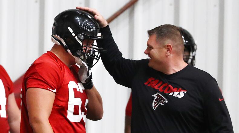 Atlanta Falcons offensive line coach Chris Morgan gives first-round draft pick Chris Landstrom a pat on the helmet after a blocking drill during rookie minicamp Saturday, May 11, 2019, in Flowery Branch.