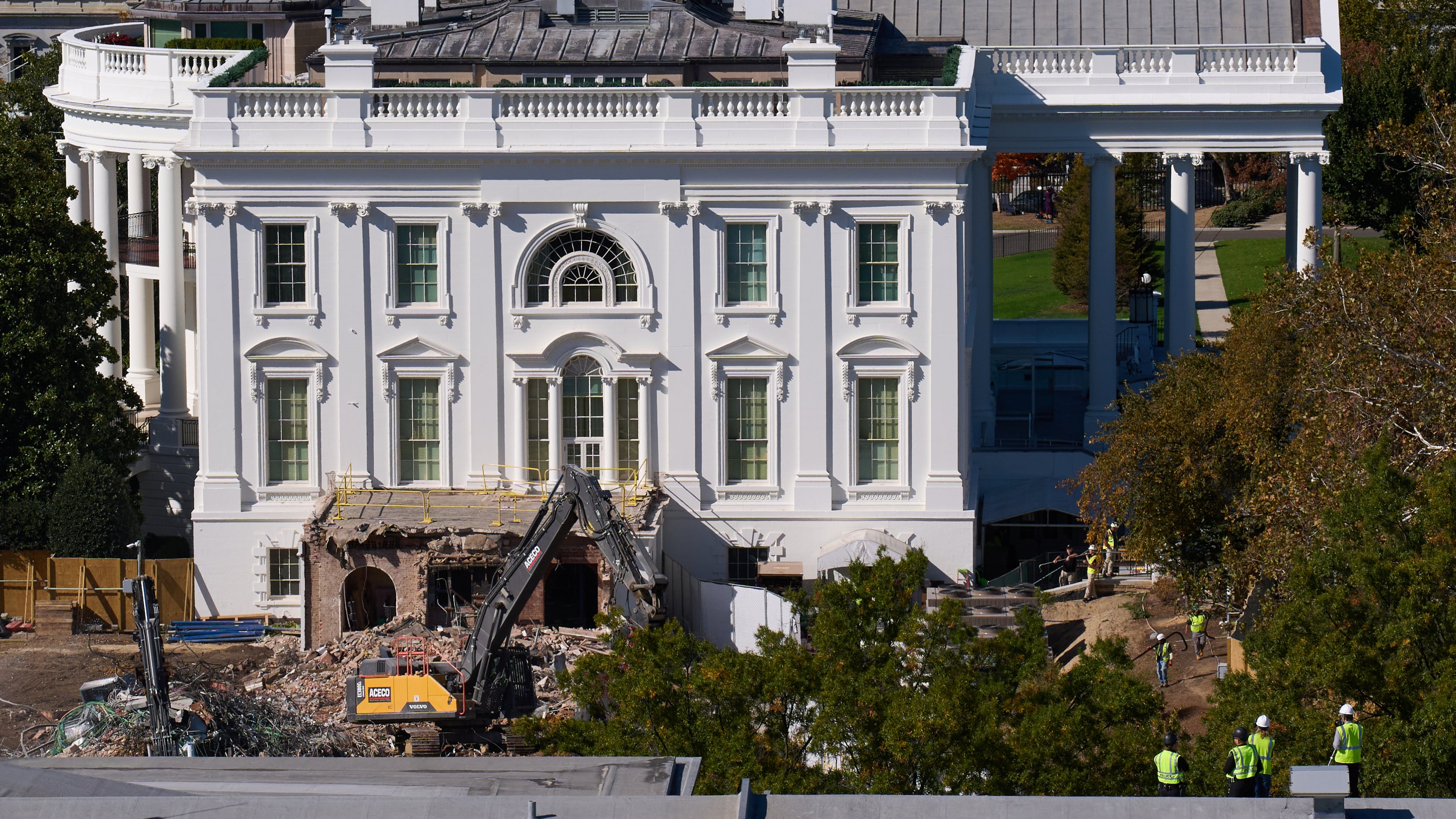 Construction workers atop the U.S. Treasury, bottom right, watch as work continues on a largely demolished part of the East Wing of the White House, Thursday, Oct. 23, 2025, in Washington, before construction of a new ballroom. (AP Photo/Jacquelyn Martin)