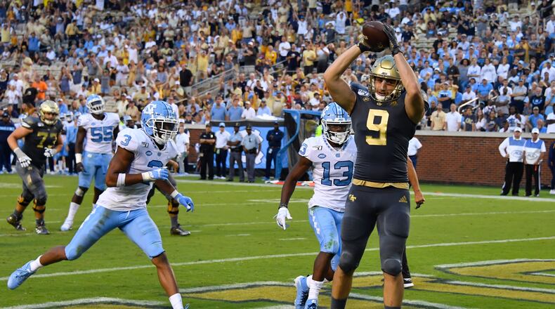 Georgia Tech tight end Tyler Davis (9) scores a touchdown with North Carolina linebacker Dominique Ross (3) and defensive back Don Chapman defending during the second half of an NCAA college football game against North Carolina, Saturday, Oct. 5, 2019, in Atlanta. North Carolina won 38-22. (Special-John Amis)