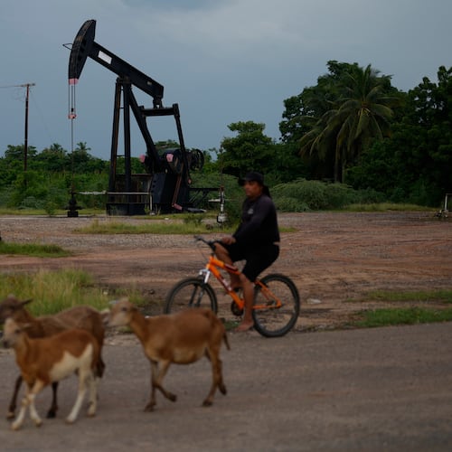 A man rides past an operating oil pumpjack in Cabimas, Venezuela, Monday, Aug. 31, 2026. (AP Photo/Ariana Cubillos)