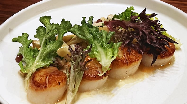 Scallops at Foundation Social Eatery in Alpharetta are served with pickled champagne grapes and foie gras chicken jus. Henri Hollis/henry.hollis@ajc.com