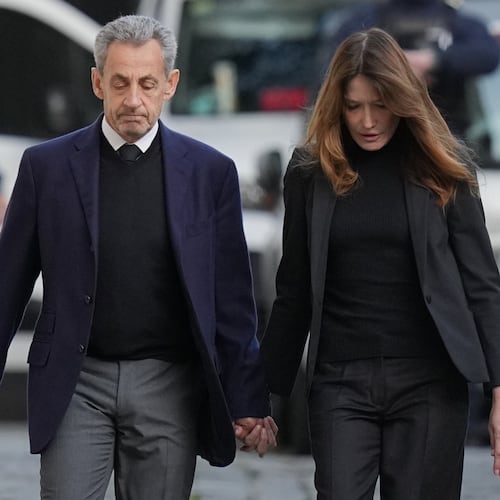 Former French President Nicolas Sarkozy and his wife Carla Bruni-Sarkozy leave their home Tuesday, Oct. 21, 2025 in Paris as Nicolas Sarkozy heads to prison to serve time for a criminal conspiracy to finance his 2007 election campaign with funds from Libya. (AP Photo/Thibault Camus)