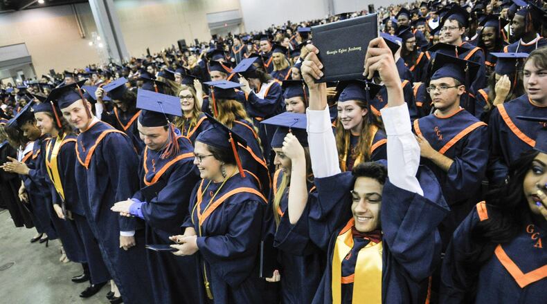 Elias Madera raises his diploma during the Georgia Cyber Academy commencement, Saturday, May 21, 2016, held at Cobb Galleria Centre in Atlanta. (Photo/John Amis)