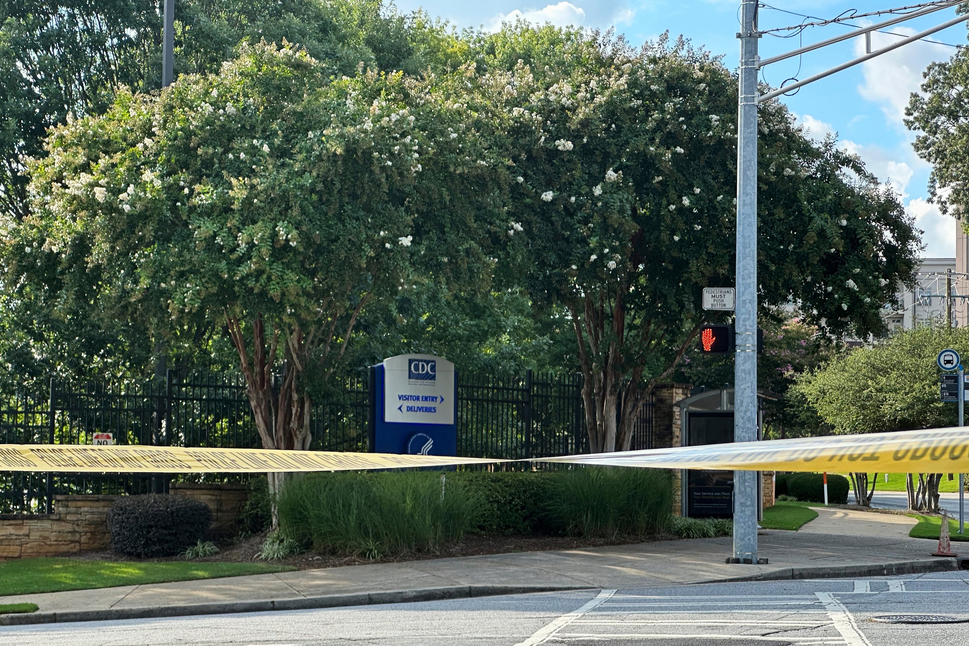 The Centers for Disease Control and Prevention headquarters sign is seen behind a police line in Atlanta on Friday, Aug. 8, 2025. (AP Photo/Jeff Amy)