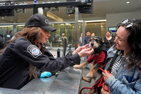 Homeland Security Secretary Kristi Noem, left, greets Jessica Medina and her dog Luna during a tour of the San Ysidro Port of Entry, Sunday, March 16, 2025, in San Diego. (AP Photo/Alex Brandon)