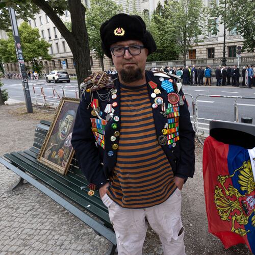 A man identified by Polish media as Robert Kuzovkov and by prosecutors as Robert K., in accordance with Polish privacy law, who they said was an artist who used the pseudonym Semyon Skrepetsky, poses for a photo with one of his paintings near the Russian Embassy in Berlin, Germany, on Friday, June 12, 2026, four days before Polish authorities said he was shot and killed in Biala Podlaska, Poland. (Vasily Krestyaninov/SOTA via AP)