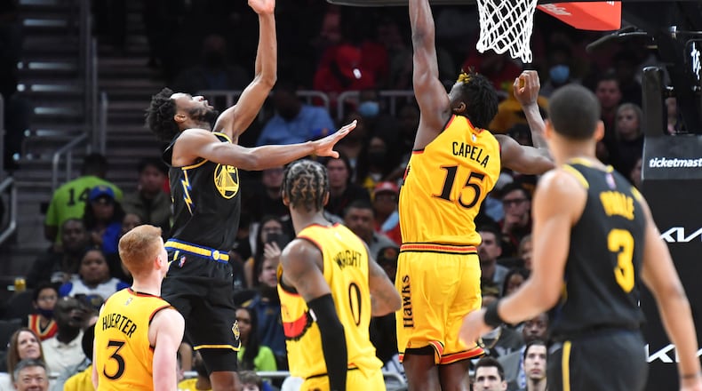 Hawks center Clint Capela blocks a shot by Warriors forward Andrew Wiggins during the first half of an NBA game at State Farm Arena. (Hyosub Shin / Hyosub.Shin@ajc.com)
