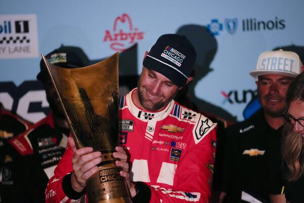 Shane van Gisbergen, center, holds the trophy after winning a NASCAR Cup Series auto race at the Grant Park 165, Sunday, July 6, 2025, in Chicago. (AP Photo/Erin Hooley)