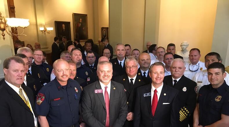 Firefighters, who watched the Senate's passage of House Bill 146, pose with bill sponsor Rep. Michah Gravley and Sen. John Albers