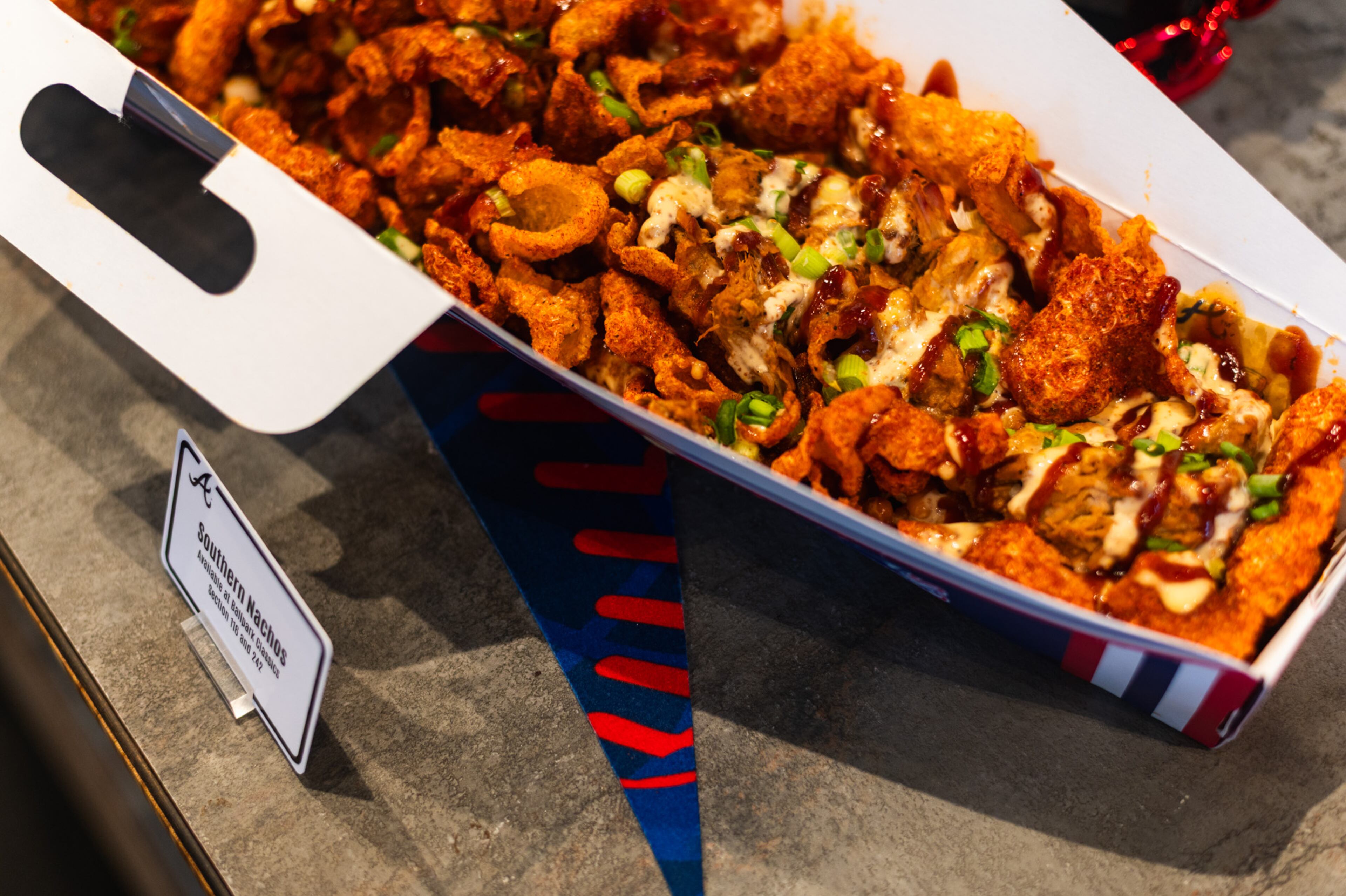 Southern nachos made with pulled pork, beans and multiple flavors of barbecue sauce on top of pork rinds. The container is called "the boom box." (Henri Hollis / henri.hollis@ajc.com)