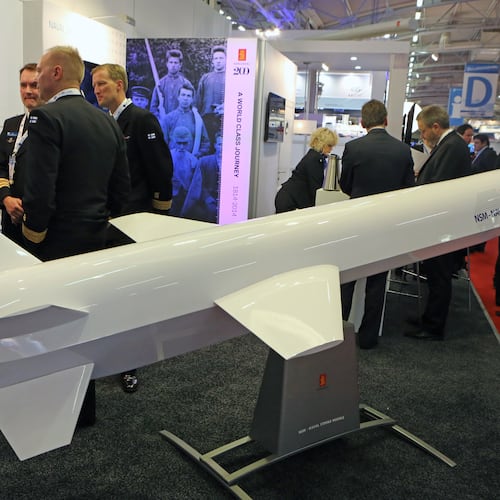 Visitors are gathered next to a display of an NSM Naval Strike Missile made by Norwegian company Kongsberg, presented at the Euronaval show, in Le Bourget, North of Paris, France, Wednesday Oct. 29, 2014. (AP Photo/Remy de la Mauviniere)