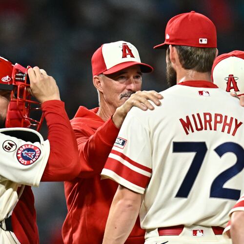 Los Angeles Angels pitcher Luke Murphy (72) speaks with pitching coach Mike Maddux, second from left, during the eighth inning of a baseball game against the Milwaukee Brewers, Friday, July 31, 2026, in Anaheim, Calif. (AP Photo/William Liang)