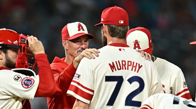 Los Angeles Angels pitcher Luke Murphy (72) speaks with pitching coach Mike Maddux, second from left, during the eighth inning of a baseball game against the Milwaukee Brewers, Friday, July 31, 2026, in Anaheim, Calif. (AP Photo/William Liang)