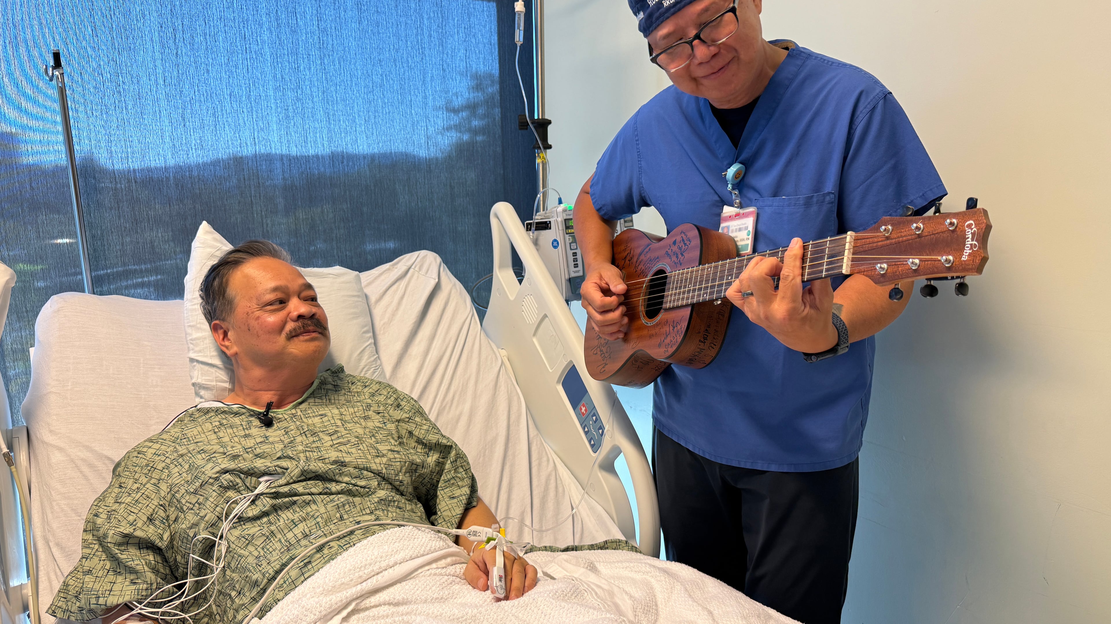 Nurse Rod Salaysay plays guitar for patient Richard Hoang in the recovery unit of UC San Diego Health in San Diego, Calif., on Sept. 30, 2025. (AP Photo/Javier Arciga)