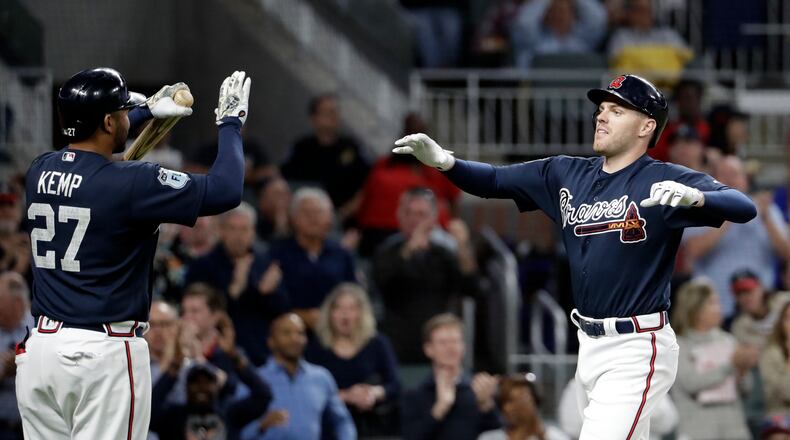Atlanta Braves' Freddie Freeman, right, high-fives teammate Matt Kemp after hitting a three-run home run in the third inning of an exhibition spring training baseball game against the New York Yankees in Atlanta, Friday, March 31, 2017. (AP Photo/David Goldman)