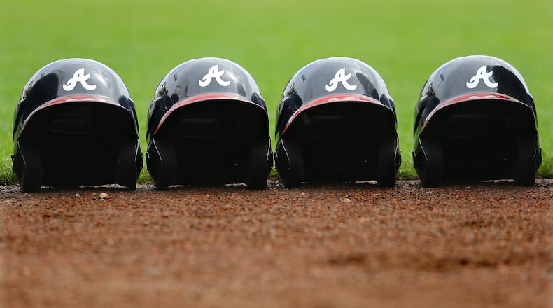 Batting helmets line the stadium field but were never put to use on a rain shortened day of spring training practice on Friday, Feb. 21, 2014, in Lake Buena Vista, FL.