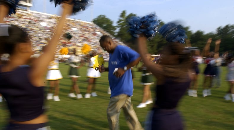 In 2002, DeKalb County superintendent Johnny Brown jogged to the stage after getting off a school bus at a rally attended by about 13,000 teachers and staff. The convocation event spurred debate over whether its cost and time were justified. Now, DeKalb plans to hold another systemwide convocation. (LOUIE FAVORITE/ STAFF)