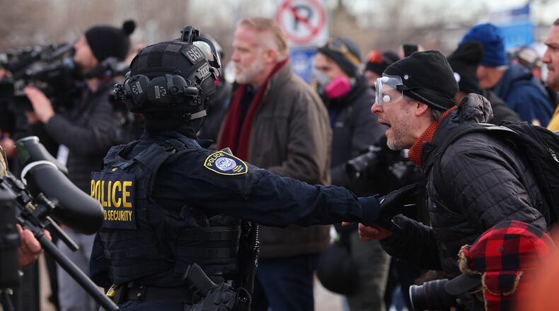 Protesters confront law enforcement outside the Bishop Henry Whipple Federal Building in Minneapolis, Friday, Jan. 9, 2026.(AP Photo/Adam Bettcher)